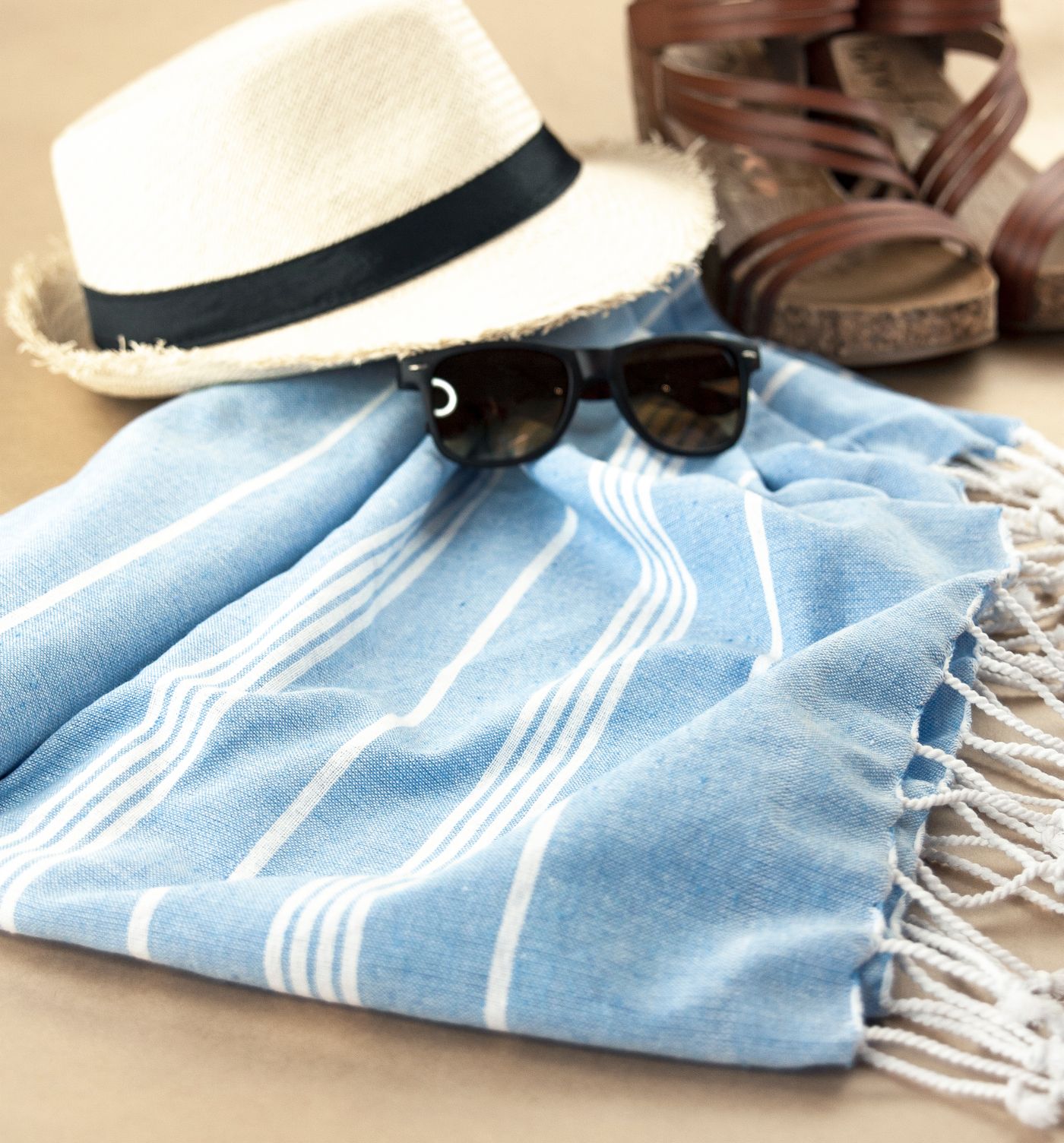 Stock photograph of beach hat, sunglasses and towel